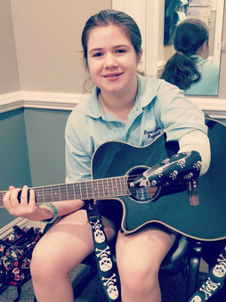 Girl playing guitar with arm prosthetic